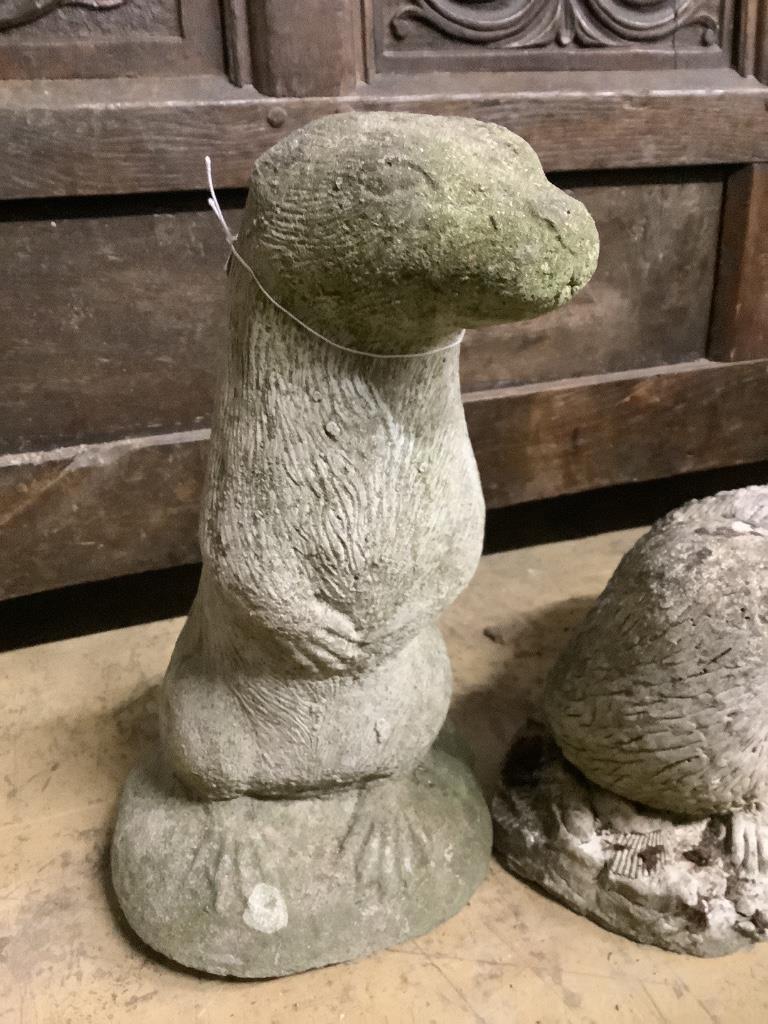 Three reconstituted stone otter garden ornaments, tallest 36cm